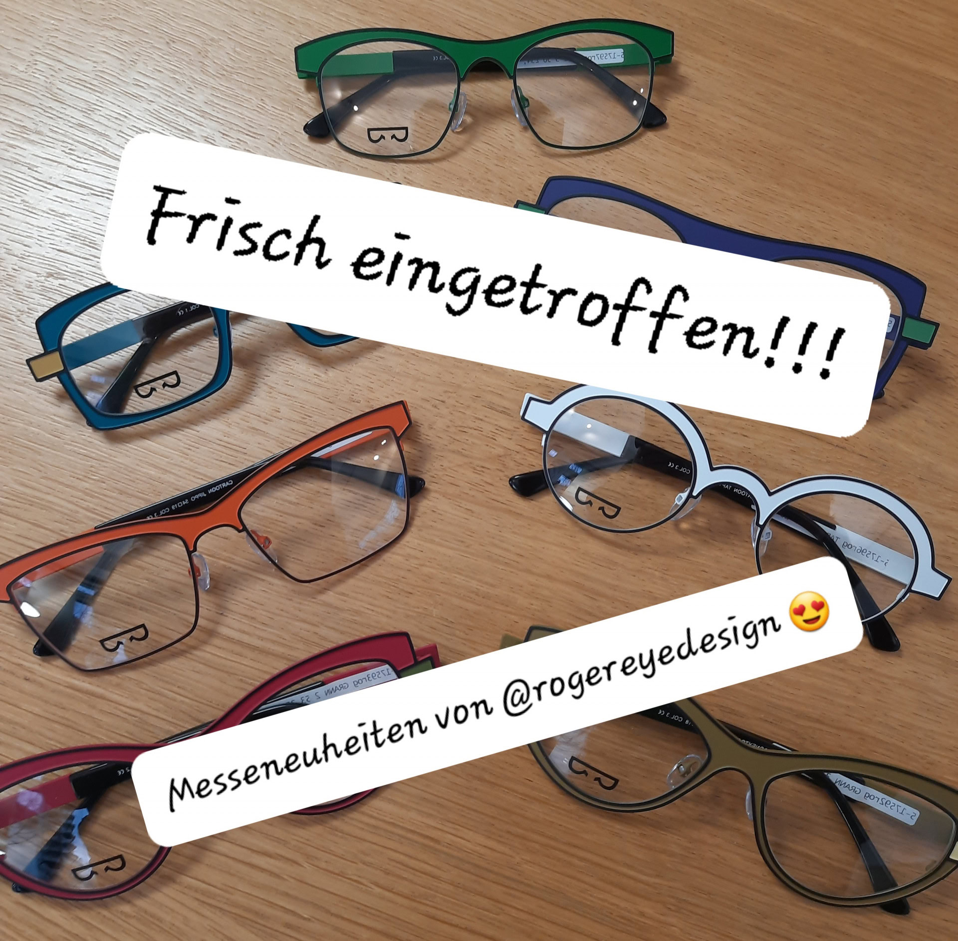 Neue Brillenmodelle auf Holztisch präsentiert.