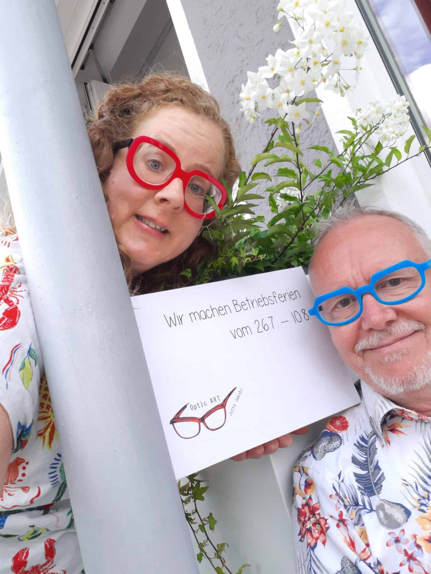 Personen mit Schild: Betriebsferienankündigung
