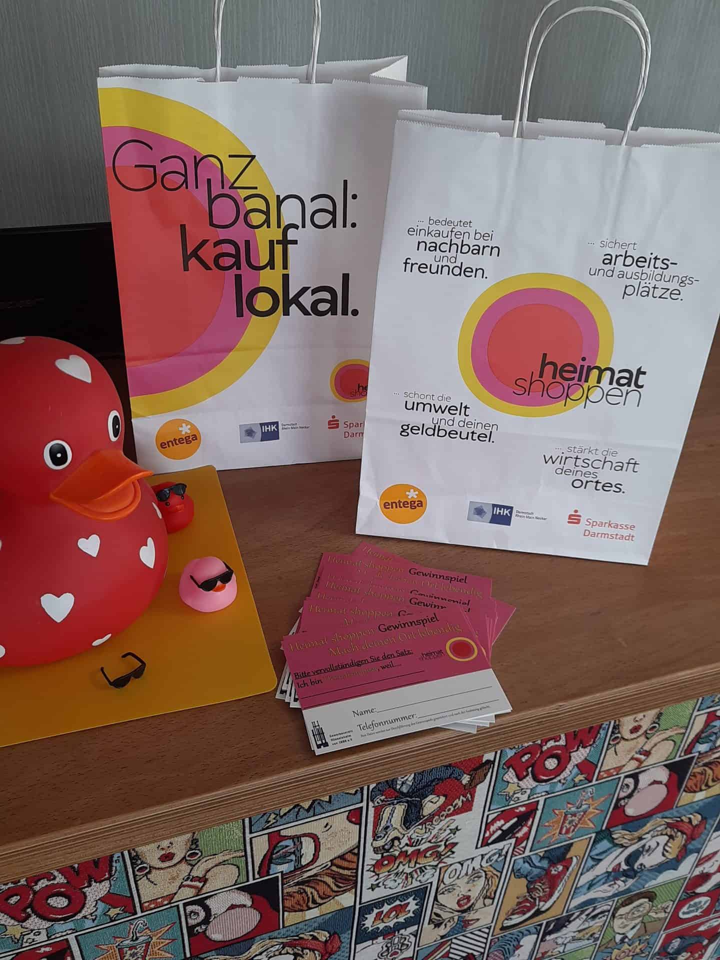 Einkaufstaschen und Gewinnspielkarten für lokales Shoppen.