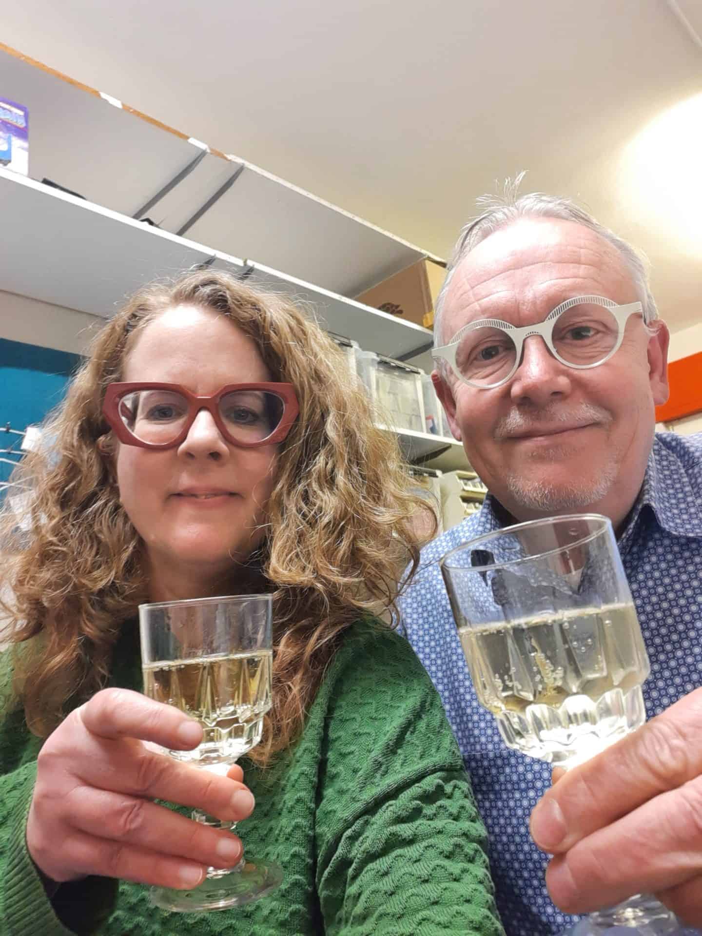 Zwei Personen stoßen mit Getränken an.