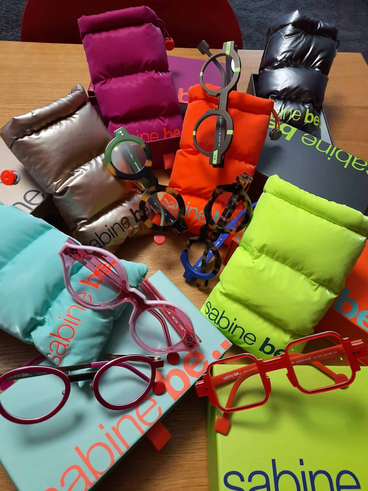 Bunte Brillen auf einem Holztisch ausgestellt.