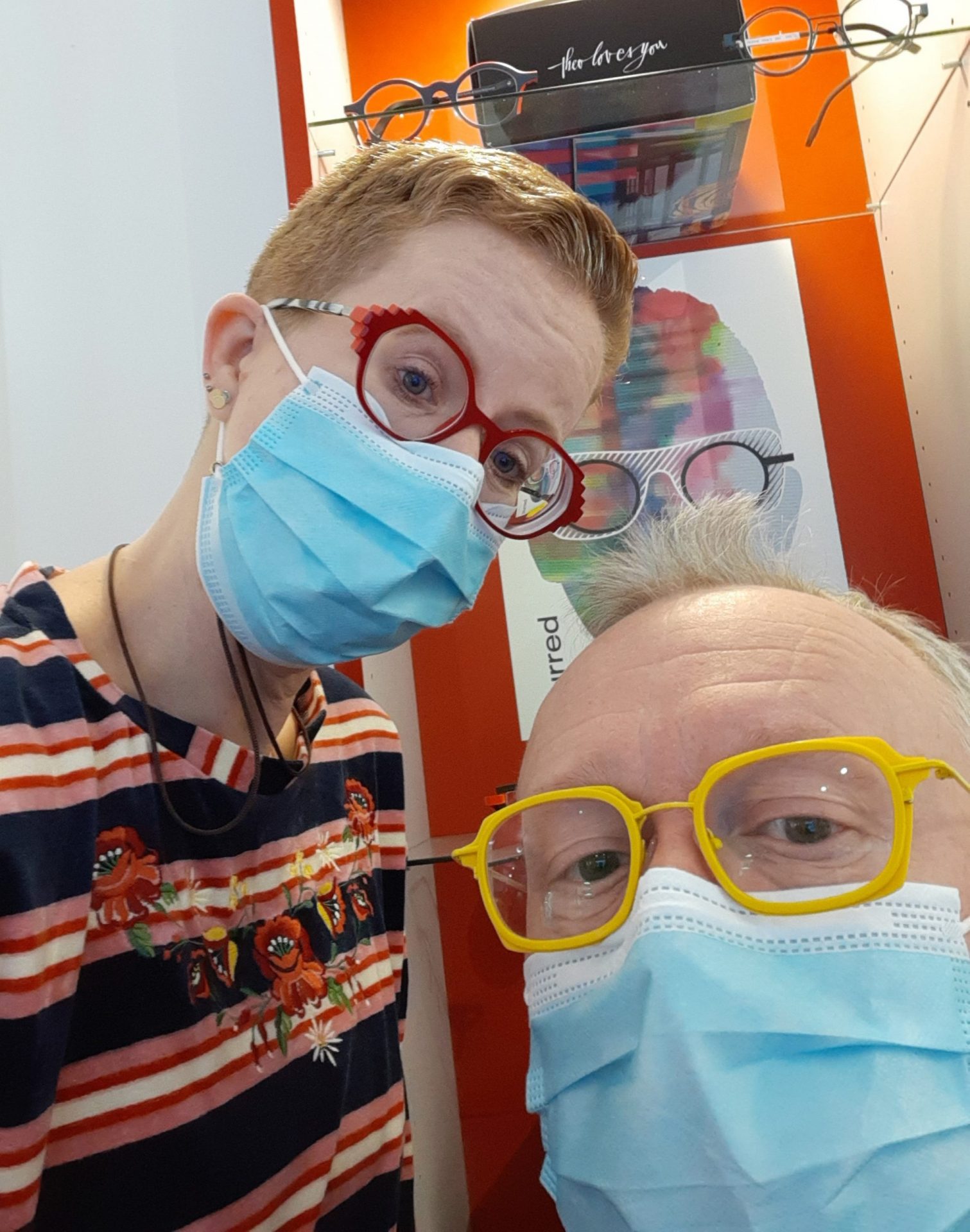 Menschen mit Brillen und Masken beim Optiker