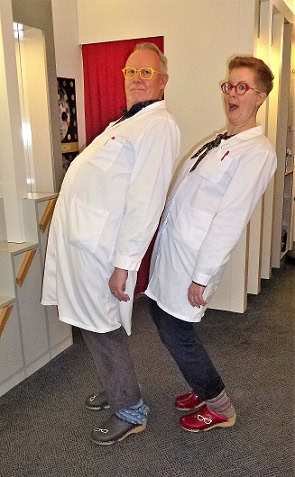 Zwei Personen in weißen Kitteln lehnen sich rückwärts.