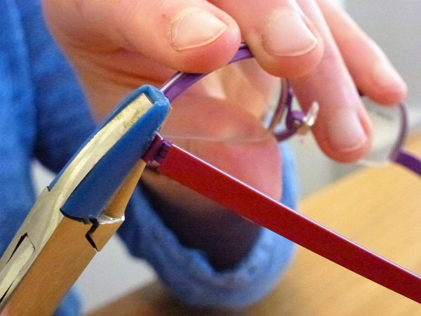 Brille wird mit Werkzeug repariert.